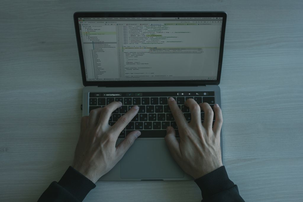 Руки на клавиатуре ноутбука: разработчик пишет код и отправляет задачи в Claude.