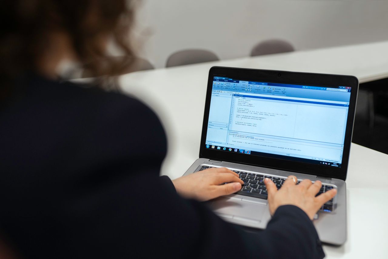 Разработчик работает в Claude Code на ноутбуке: код в редакторе, AI-агент генерирует правки.